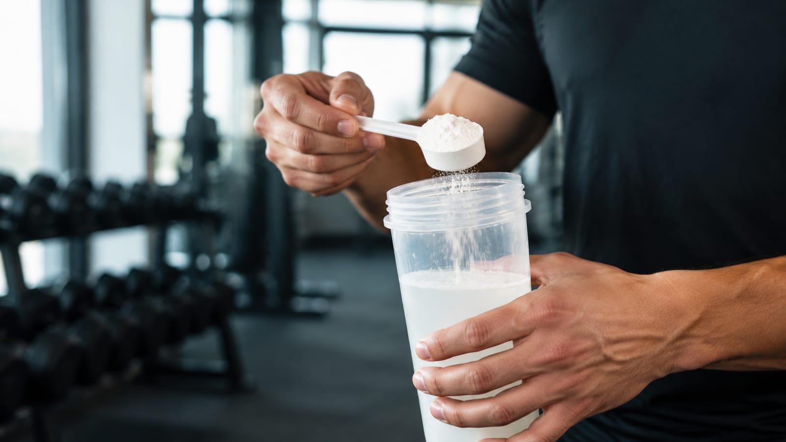 Athlete mixing creatine into water during a structured strength training routine